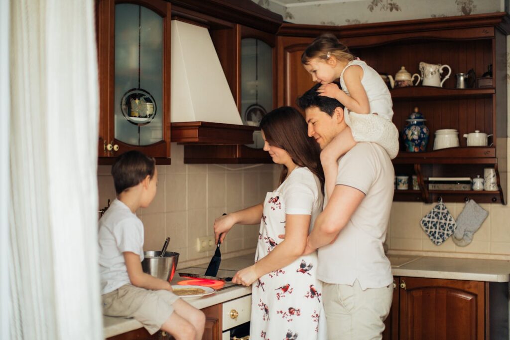 Vater Mutter Tochter Sohn kochen gemeinsam Küche Kindern kochen beibringen Schritt für Schritt